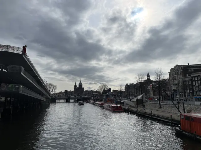 A canal and waterfront buildings beneath dark clouds.