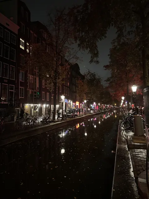 A canal between illuminated buildings at night.