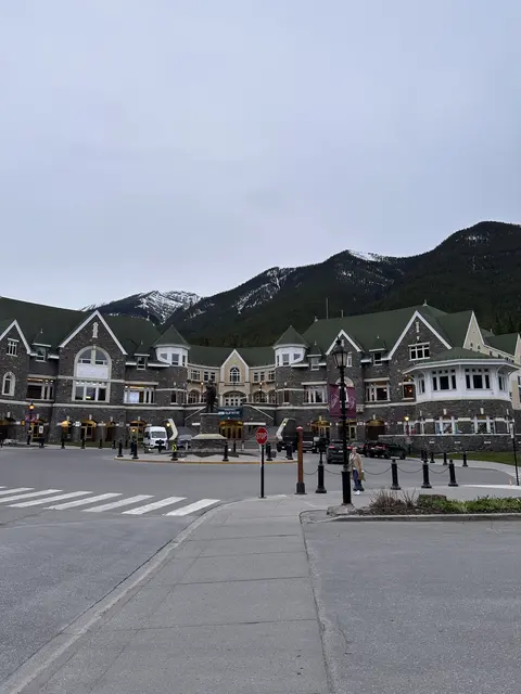 A mountain town street with peaked roofs and dark hills beyond.