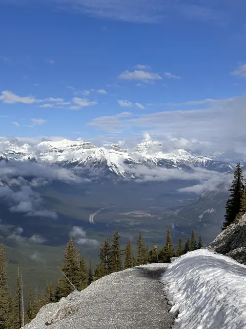 Snow-capped mountains seen from a rocky overlook.