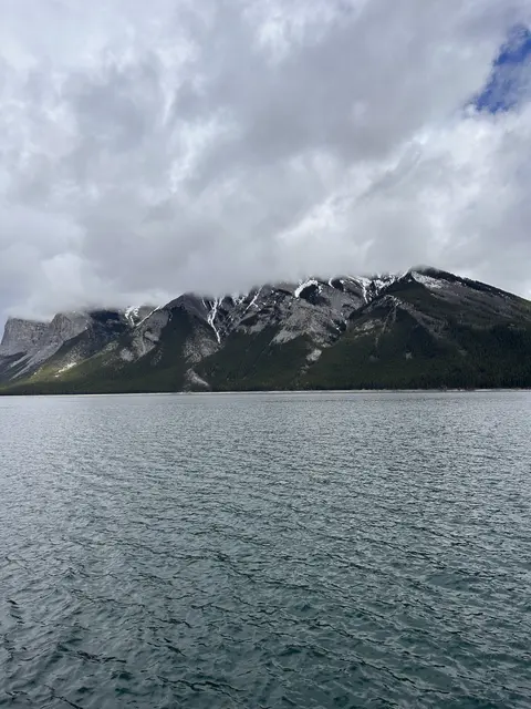 A blue lake beneath snow-dusted mountain peaks.