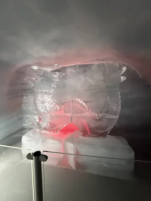 A dragon sculpture carved from clear ice glows with red light.