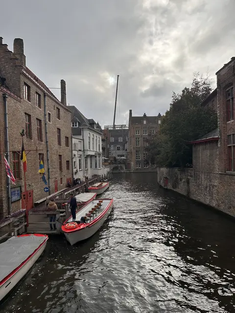 Boats on a narrow canal between old brick buildings.
