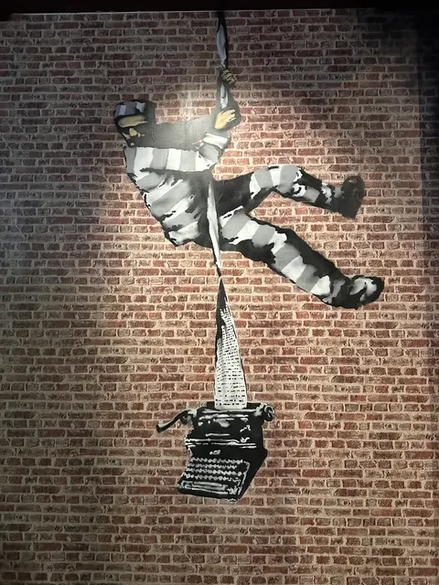 A stencil-style mural on a brick wall.
