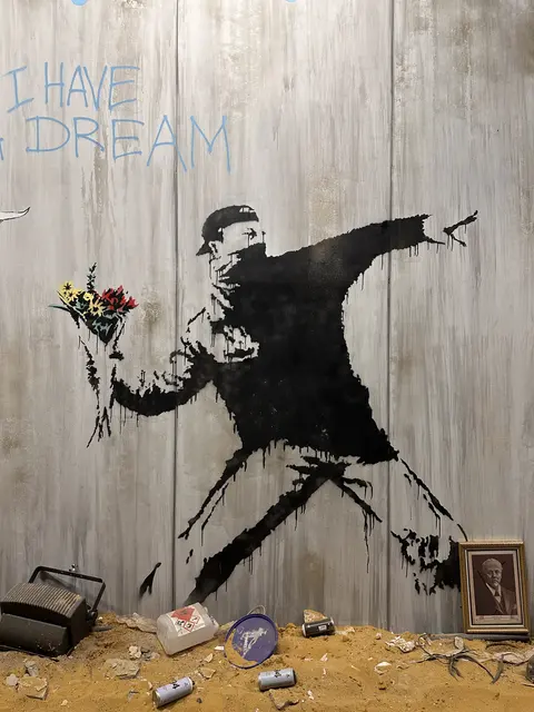 A mural of a figure throwing a bouquet of flowers.