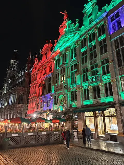 Historic facades lit in green and red at night.