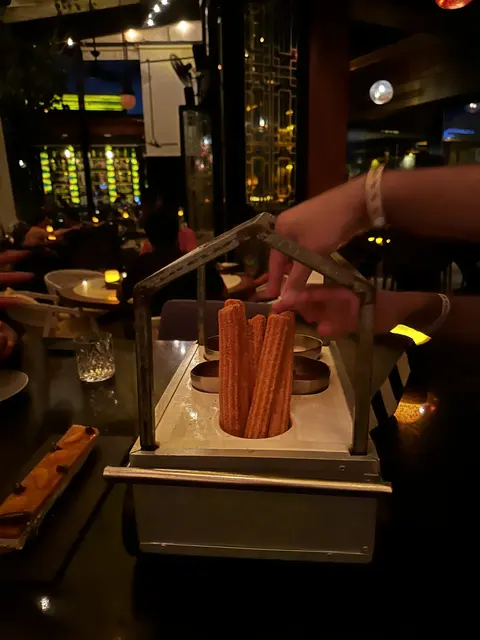 A drink being prepared in a copper-colored mug at a bar.