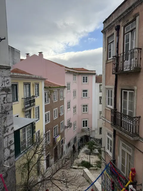 Pastel buildings and balconies beside a narrow street.