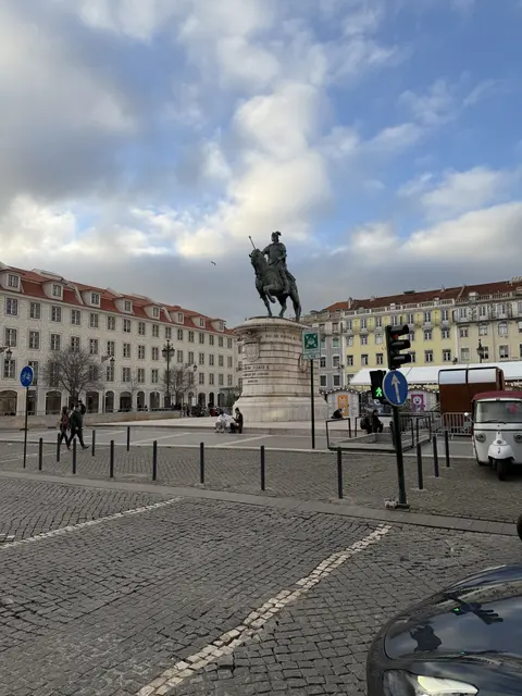 An equestrian statue in a broad cobbled square.