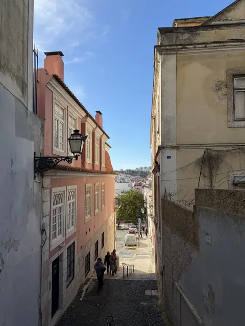 A narrow lane descending between colorful buildings.