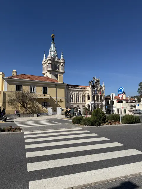 A historic church and tower beyond a pedestrian crossing.