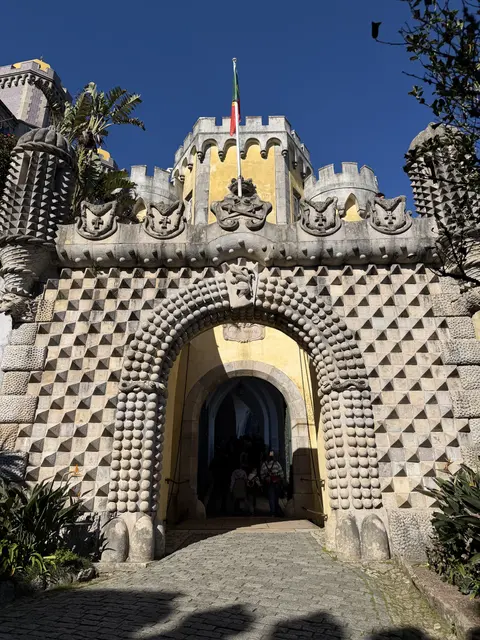 A patterned stone gateway with ornate towers and arches.