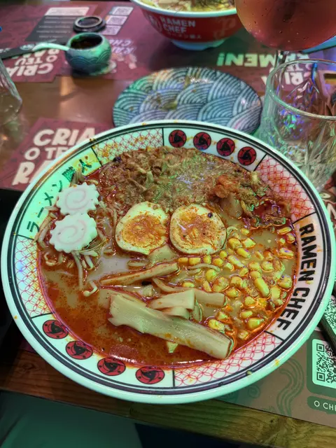 A bowl of noodles with egg and vegetables.