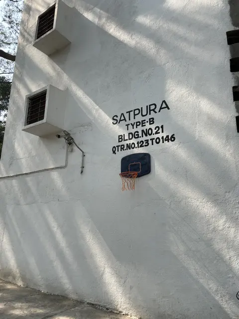A white residential wall with a building name painted on it.