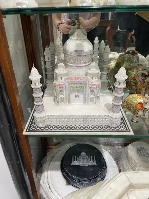 A miniature white marble-style monument in a display cabinet.