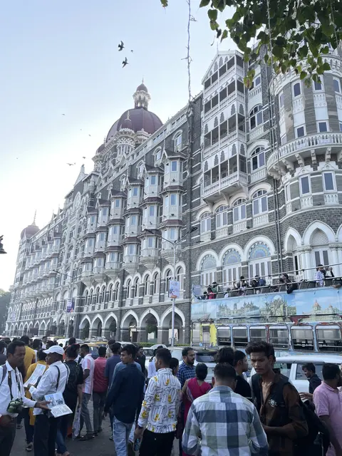 A grand historic hotel overlooking a crowded street.