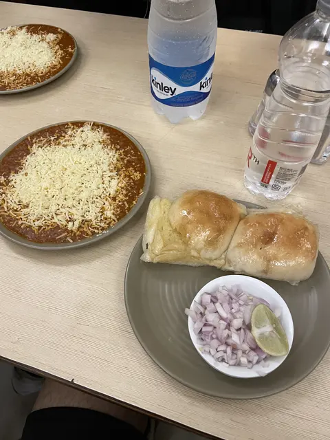 Bread rolls and dishes of food on a cafe table.
