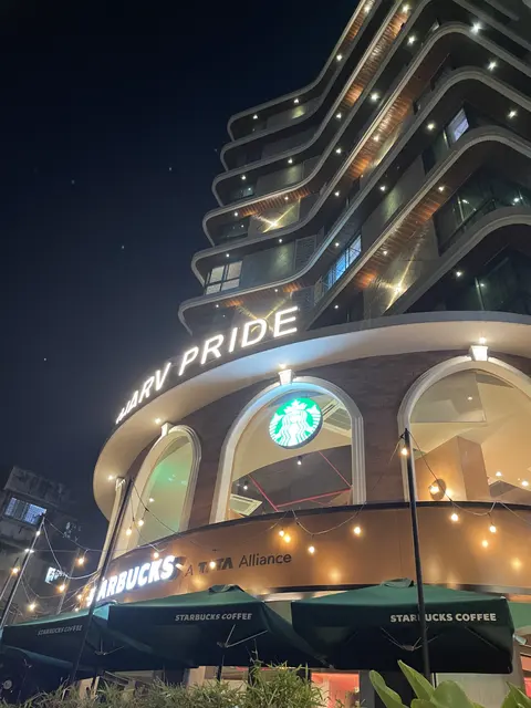 An illuminated building with a cafe at street level.