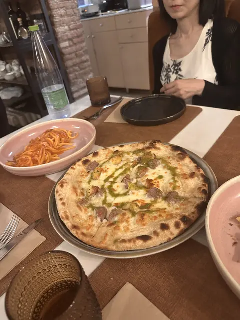 Pizza and pasta on a restaurant table.