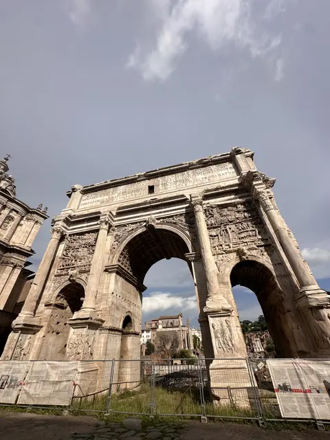 A carved stone triumphal arch beneath a blue sky.
