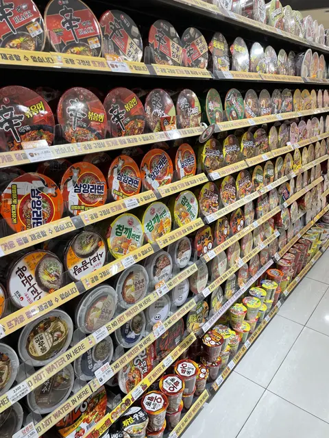 Shelves filled with colorful instant noodle bowls.