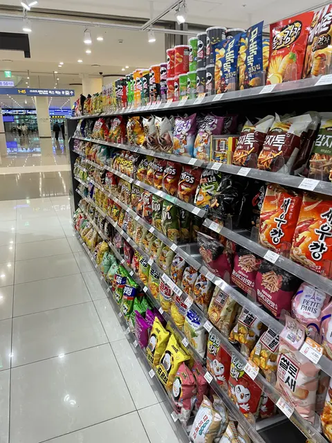 Packets of snacks lining a convenience store aisle.
