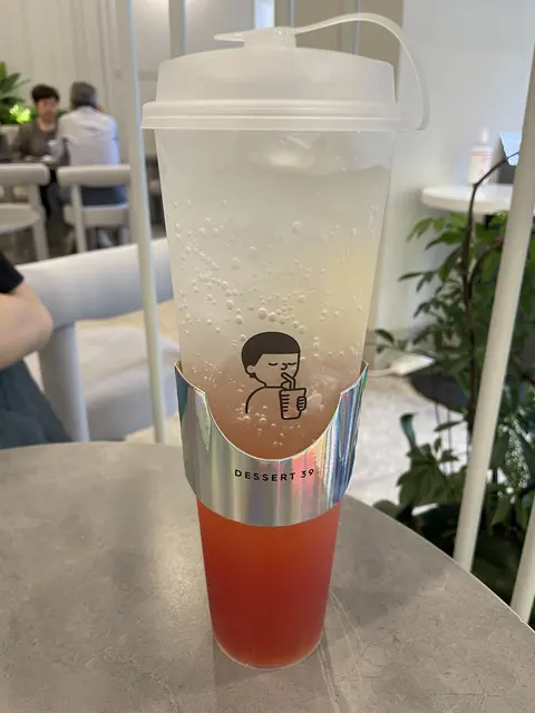 A tall layered fruit drink on a cafe table.