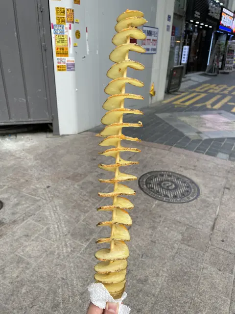 A spiral-cut potato on a long skewer.
