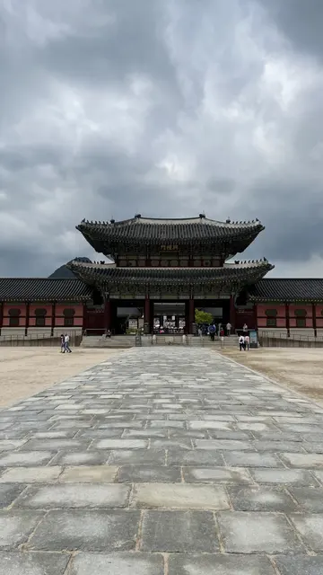 A traditional palace gate beyond a broad stone courtyard.