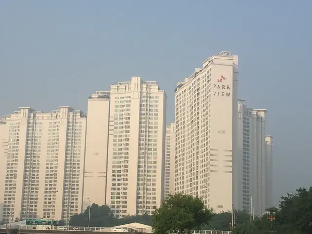 Rows of tall apartment buildings in warm daylight.