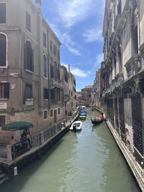 A narrow canal with boats between colorful buildings.