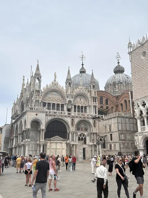 Visitors gathered in front of an ornate basilica.