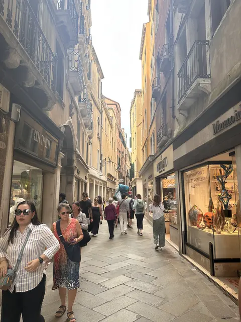 Pedestrians walking through a narrow shopping lane.