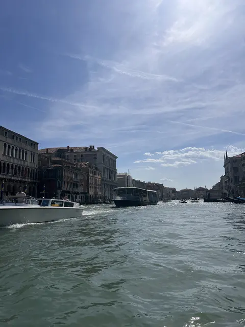 Sunlight over a broad canal seen from the water.