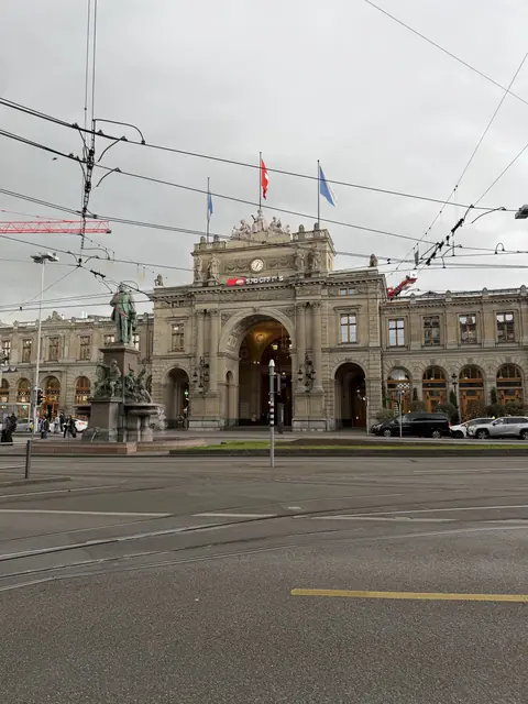 The main station façade and a statue beneath the city sky.